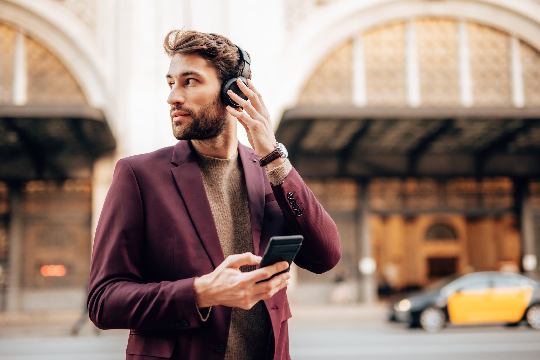 Man with headphones looking in the distance on a busy street
