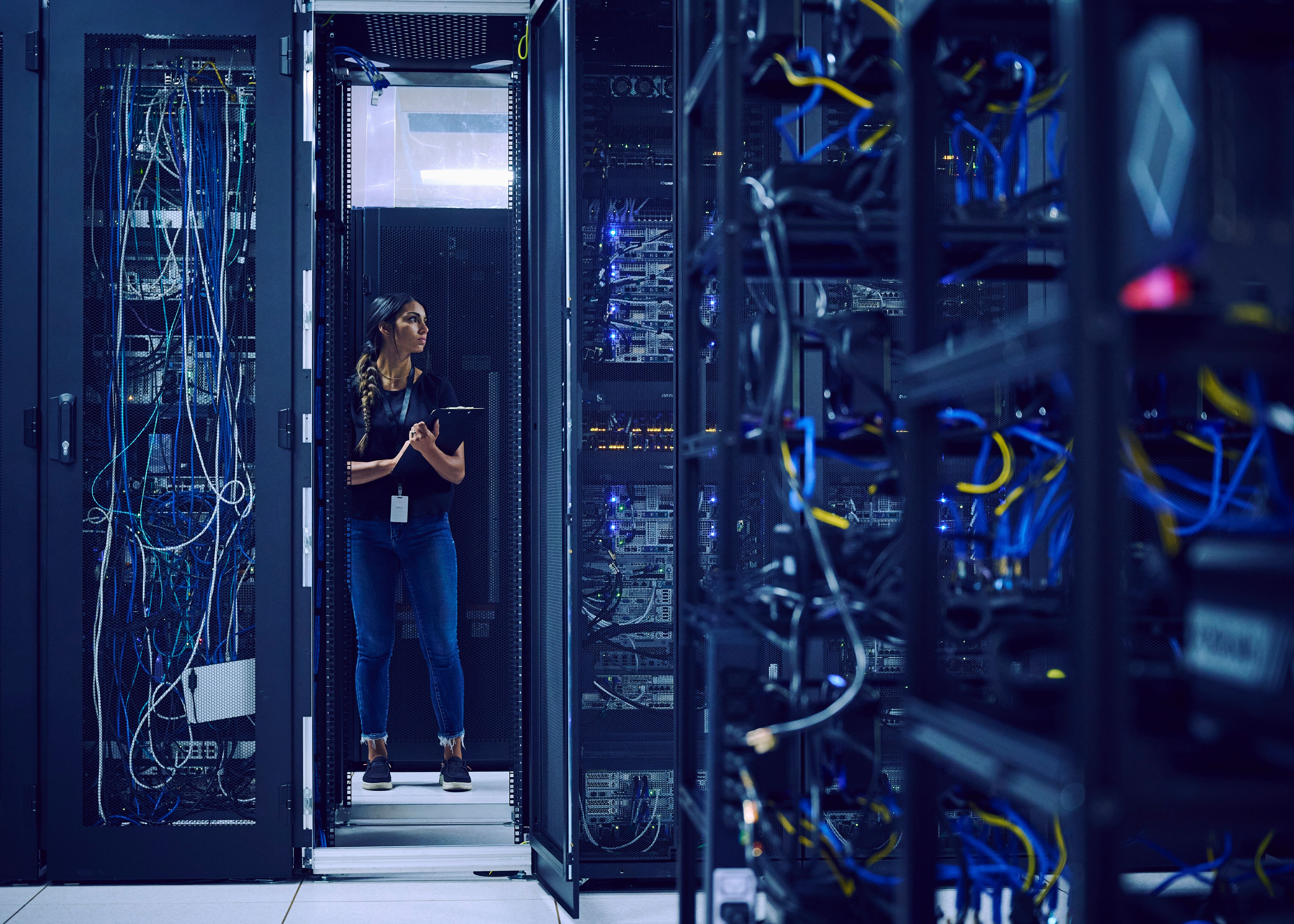 Woman standing in data center holding a tablet