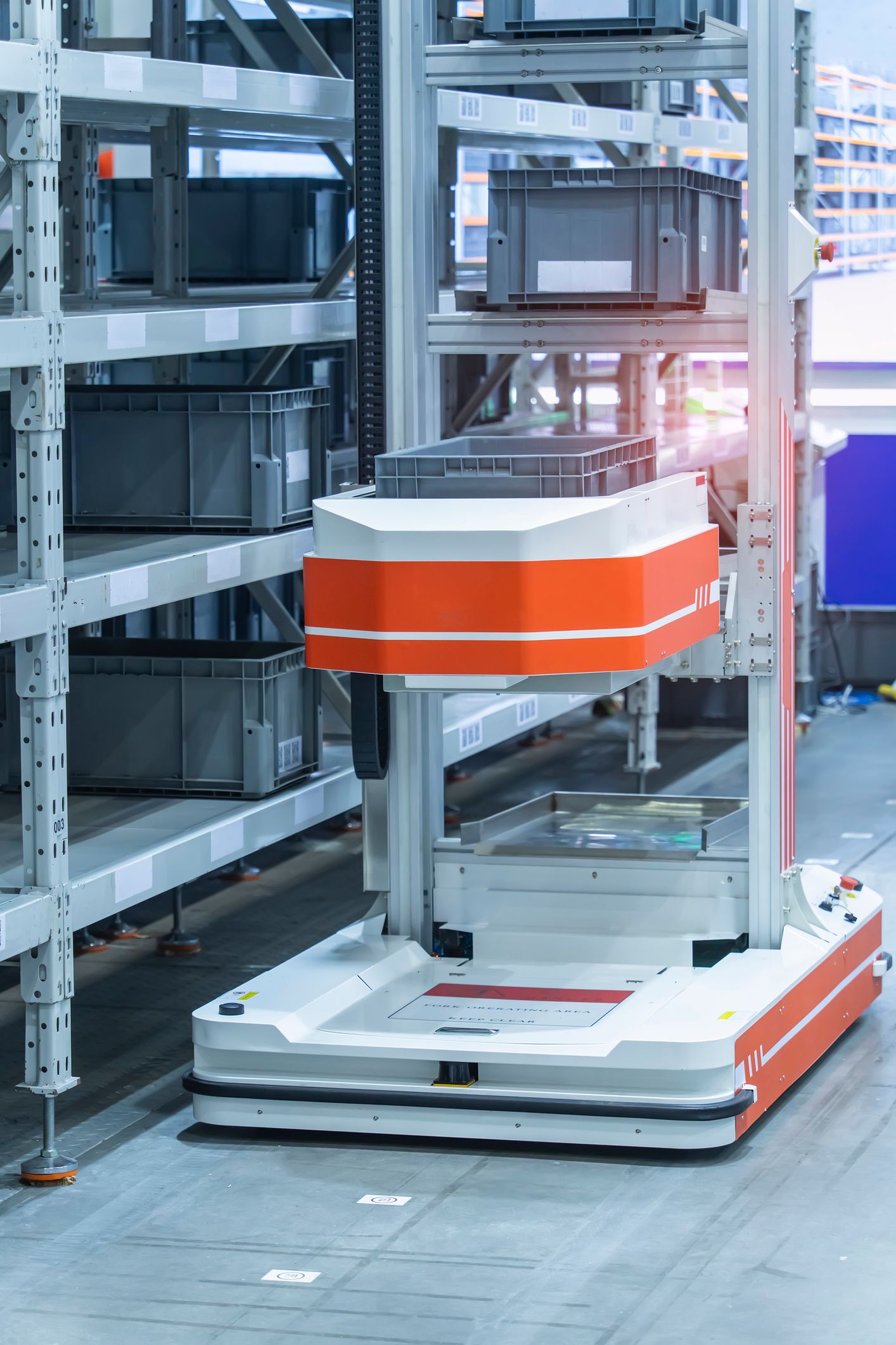 AGV in a warehouse lifting boxes