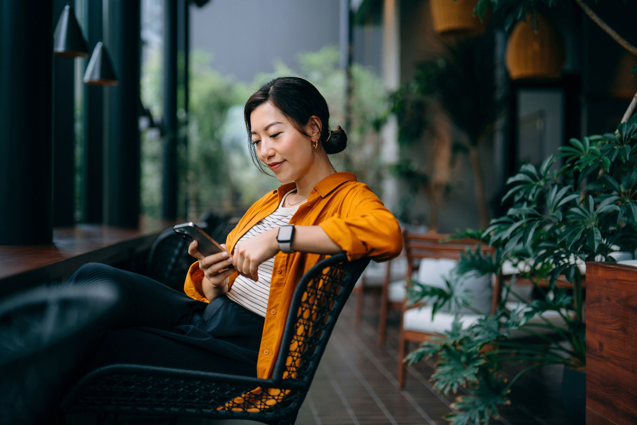 Woman looking at a smartphone in a modern office space
