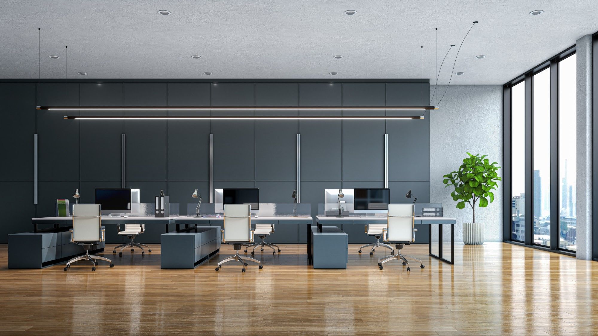 Empty open-plan office with rows of white desks, desktop computer monitors, and floor-to-ceiling windows