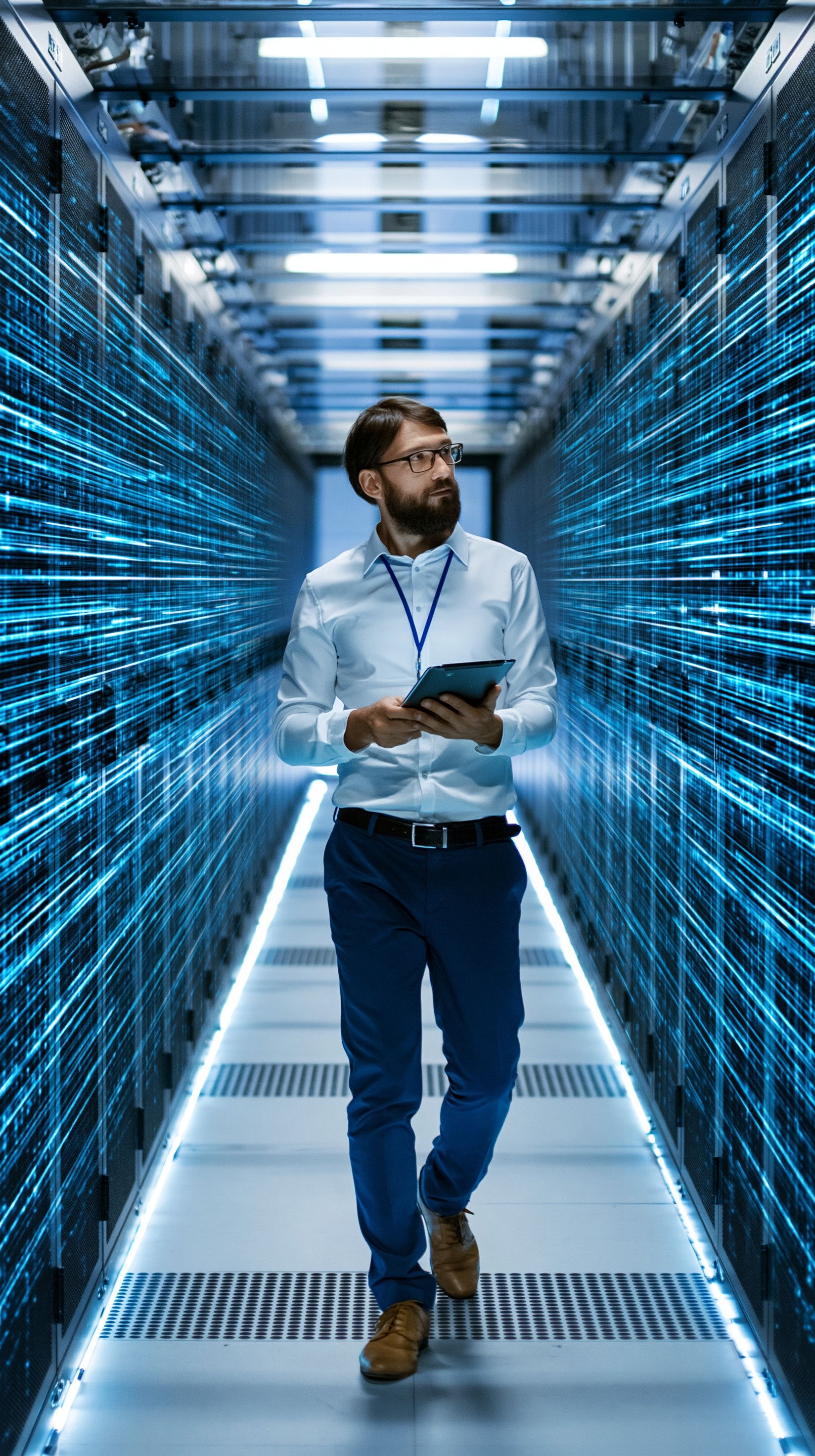 IT professional walking down an aisle in a data center