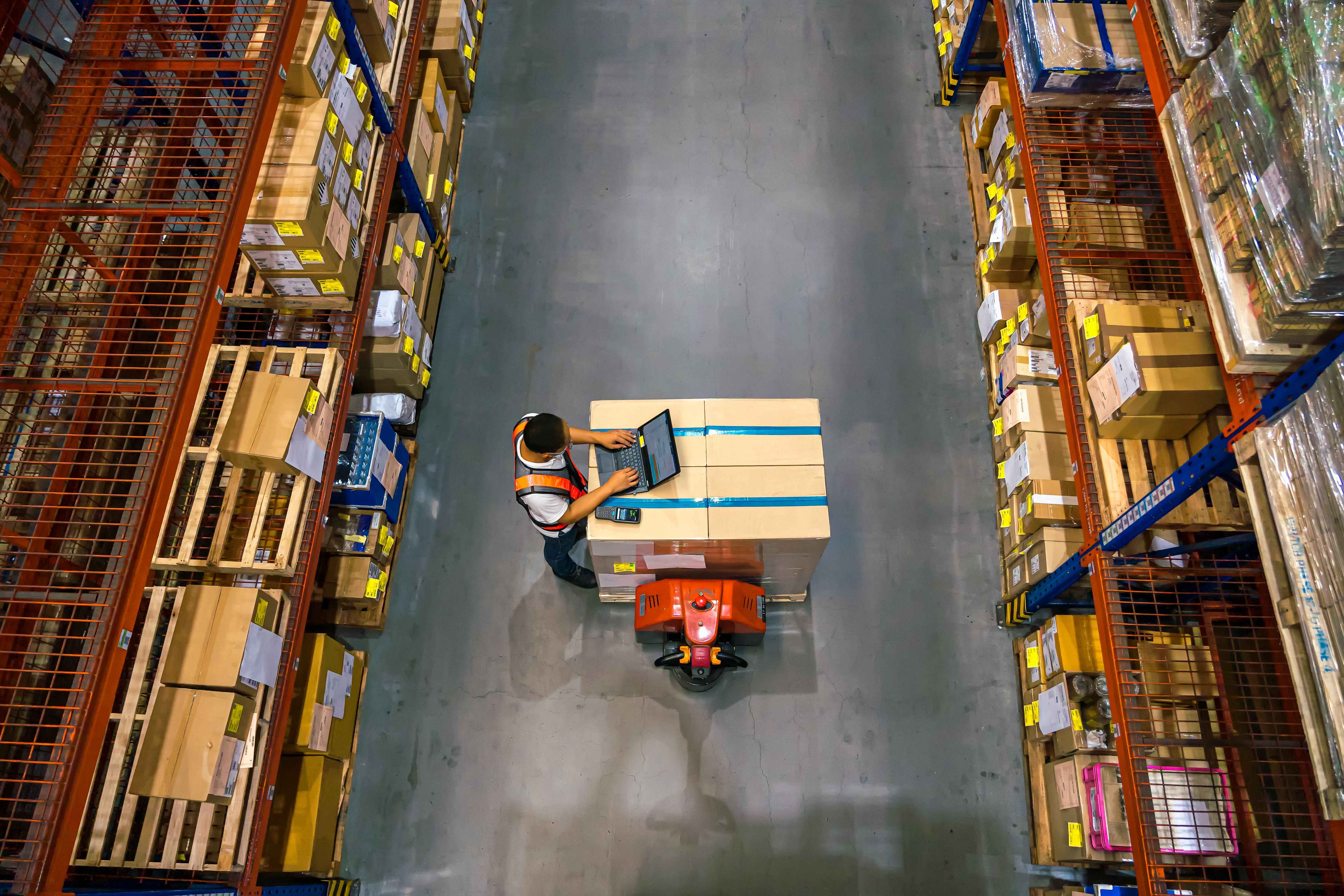 Single person working in a warehouse on a laptop