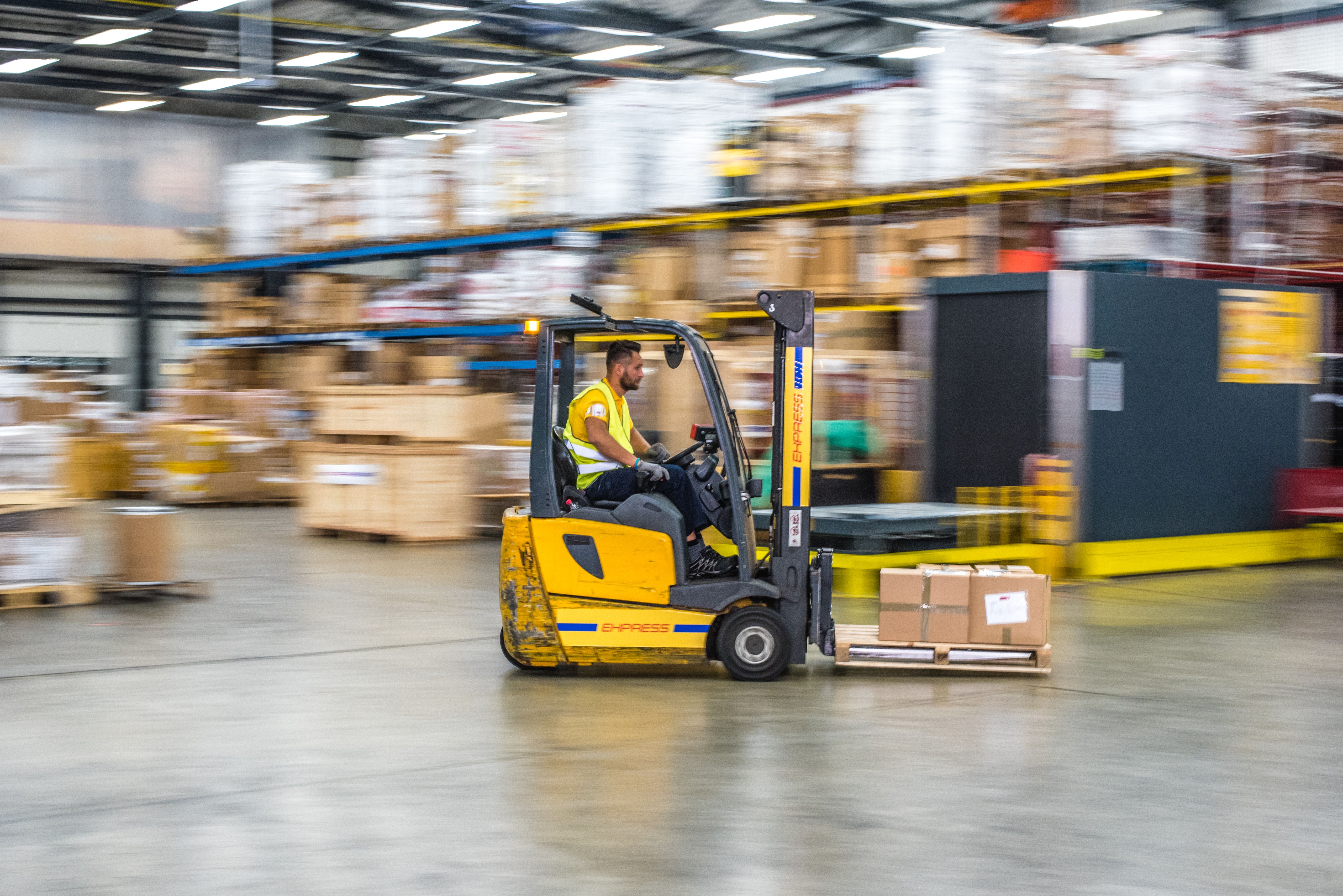 Single forklift moving a pallet in a warehouse